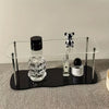 Front view of 2-tier clear acrylic display riser for perfume and cologne organization.