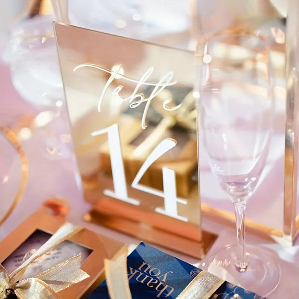 Gold acrylic table number displayed at elegant wedding reception table with floral centerpiece