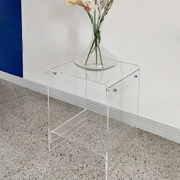Sturdy acrylic coffee table supporting books and decor