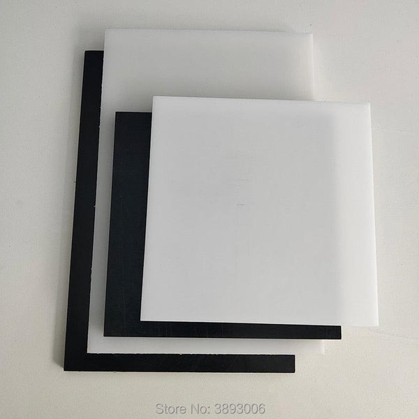 Black and white HDPE sheet being machined on a CNC router