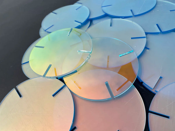 Laser engraved rainbow acrylic disc illuminated on LED base showing intricate design patterns