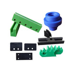 Assortment of custom CNC-machined plastic parts in multiple colors including green brackets black insulators blue spherical components for industrial applications