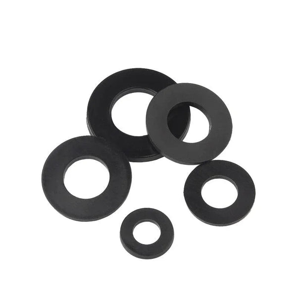 Close-up of white and black nylon flat washers in multiple sizes