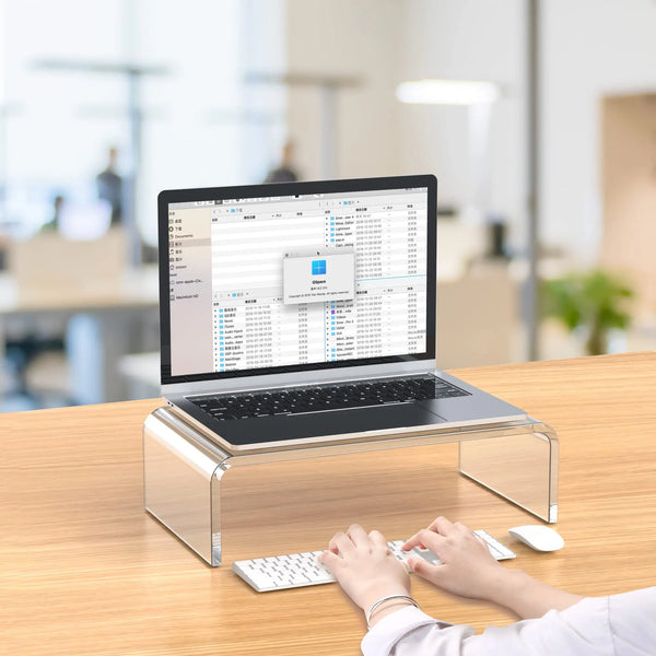 Professional office worker using transparent PMMA acrylic laptop riser for improved posture and neck pain relief