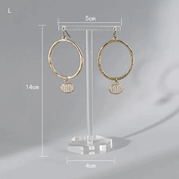 Stud earrings showcased on transparent acrylic stand