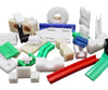 Assorted industrial plastic machined parts including rollers, guide rails, and wear strips at BeePlastic.