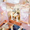 Gold acrylic table number displayed at elegant wedding reception table with floral centerpiece