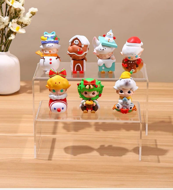 Clear acrylic tiered display stand showcasing jewelry rings and earrings in retail store