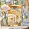 Gold acrylic wedding table numbers 1-25 complete set with clear stands on white background